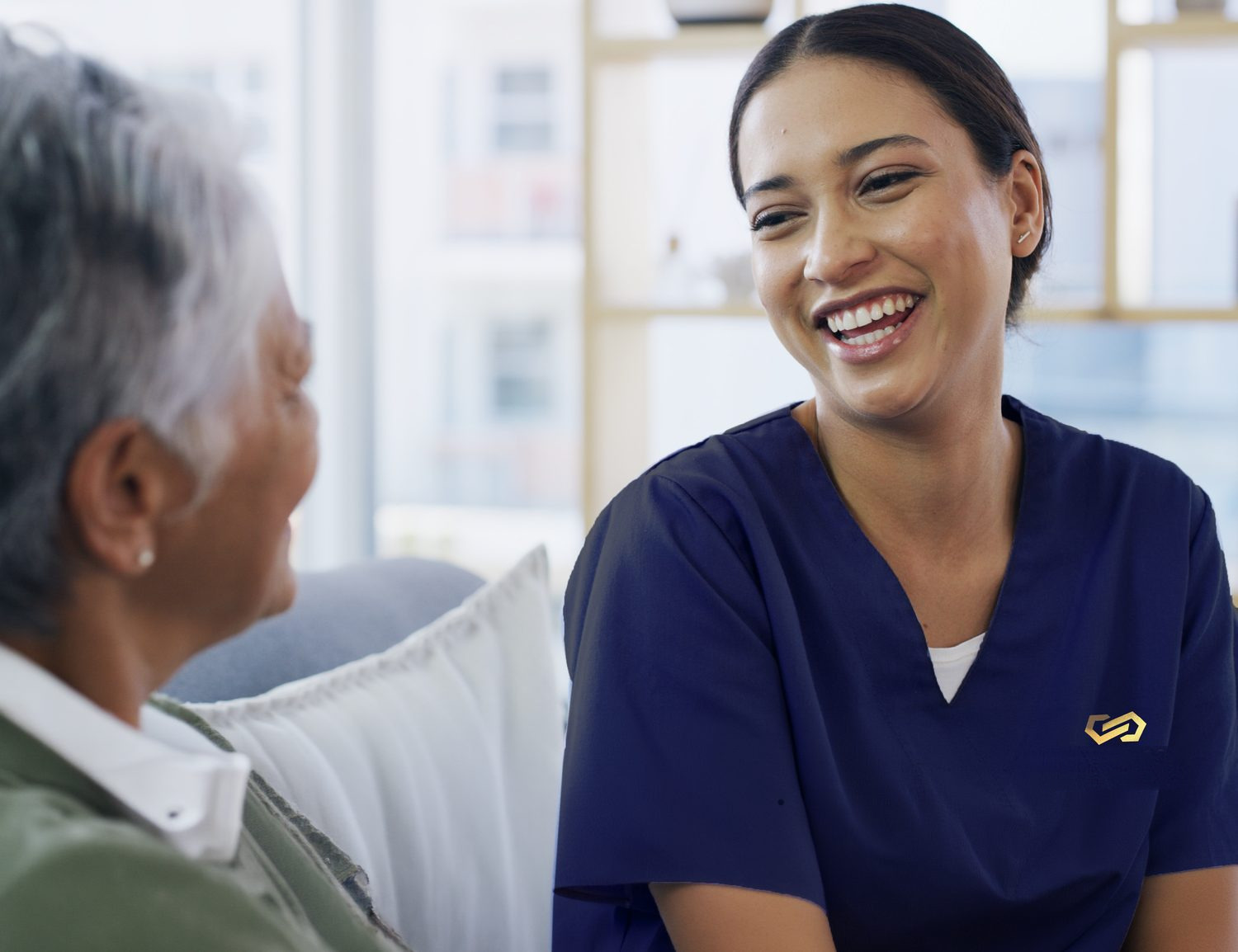 A caregiver laughing with a smiling resident